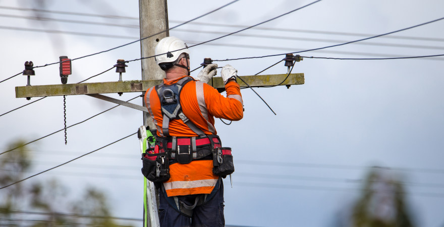 A linesman connects a new house in Sheffield, Canterbury to the grid